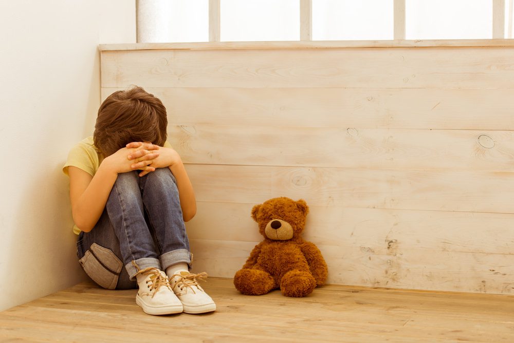 Punished little boy sitting in the corner